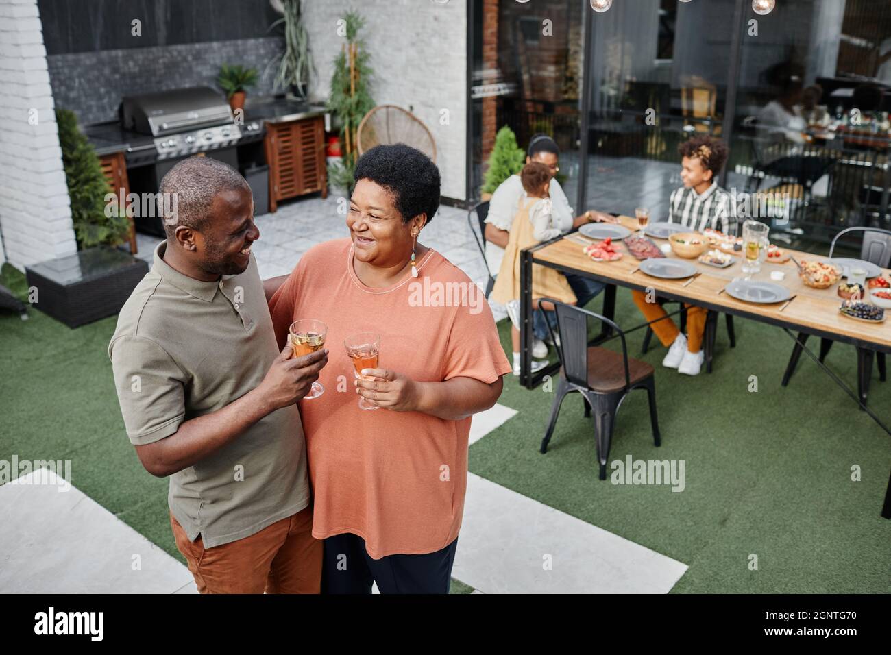 High angle portrait of mature African-American couple chatting while enjoying family gathering at outdoor terrace, copy space Stock Photo