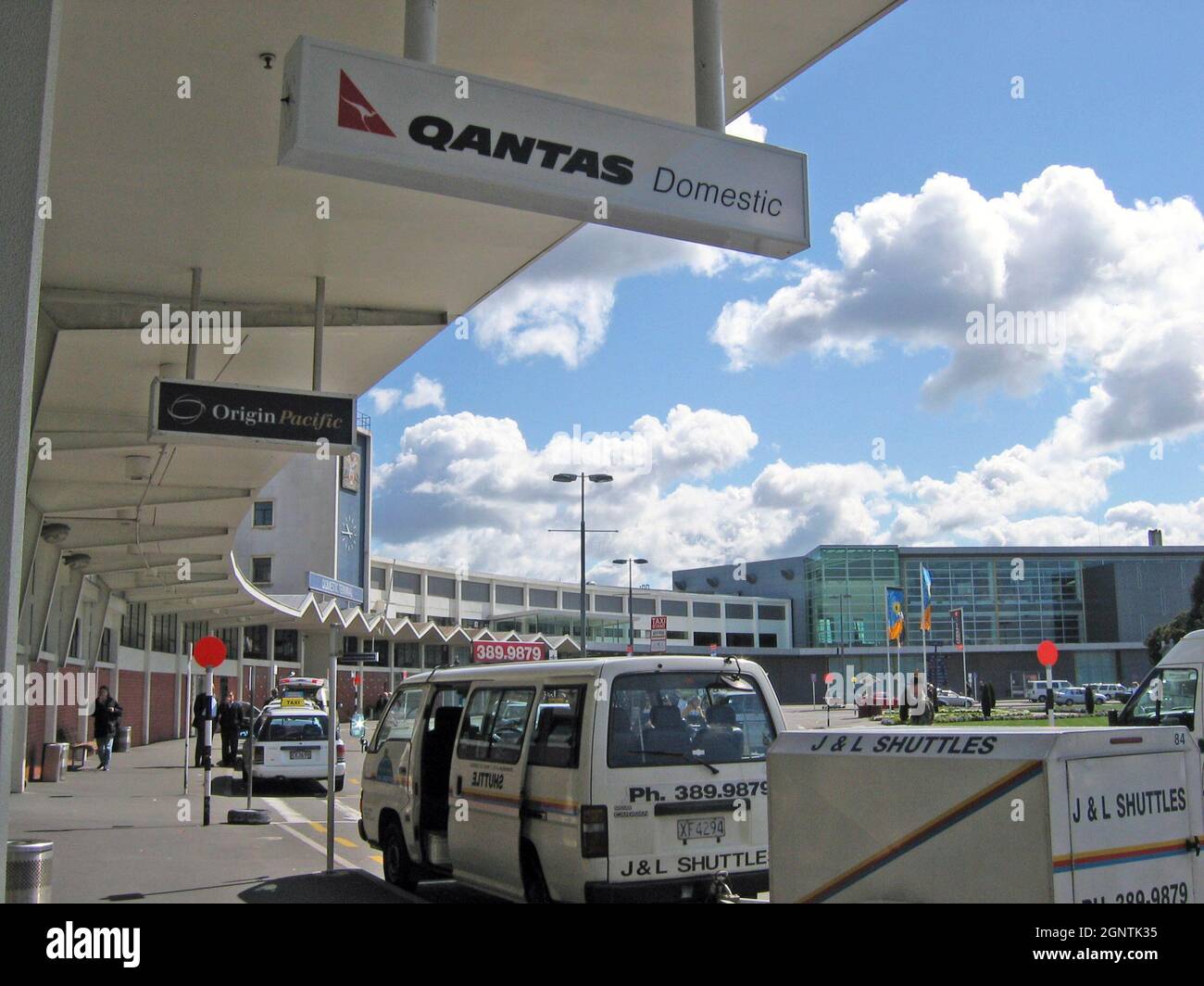 Auckland International Airport domestic terminal exterior with Qantas Domestic and Origin Pacific signs from the overhang in September 2004. Stock Photo