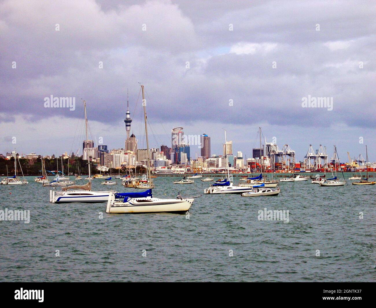 An overcast October day in Auckland, New Zealand with the skyline in the background and sailboats on the water in the foreground. The nickname for the city is the City of Sails. Stock Photo