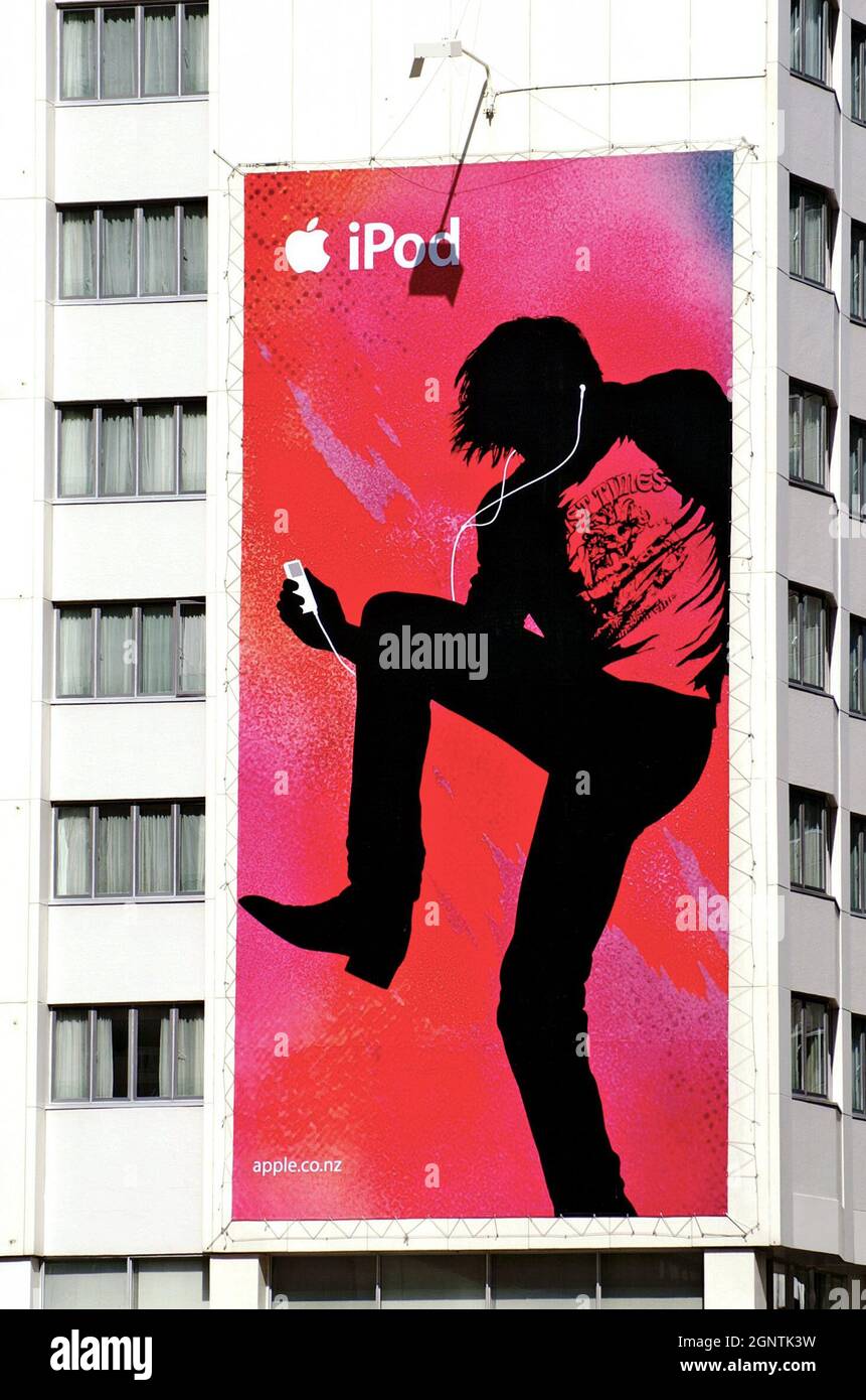 A pink, red, and black banner of a person dancing with an Ipod connected to their ears hangs on the side of a building in Auckland, New Zealand on December 9, 2005. Stock Photo