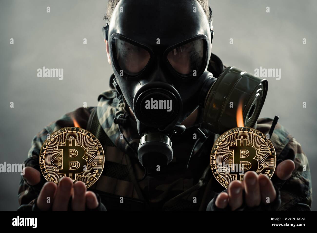 man in gas mask holding bitcoin coins in hands. Сoin mining ecology problem  concept Stock Photo - Alamy
