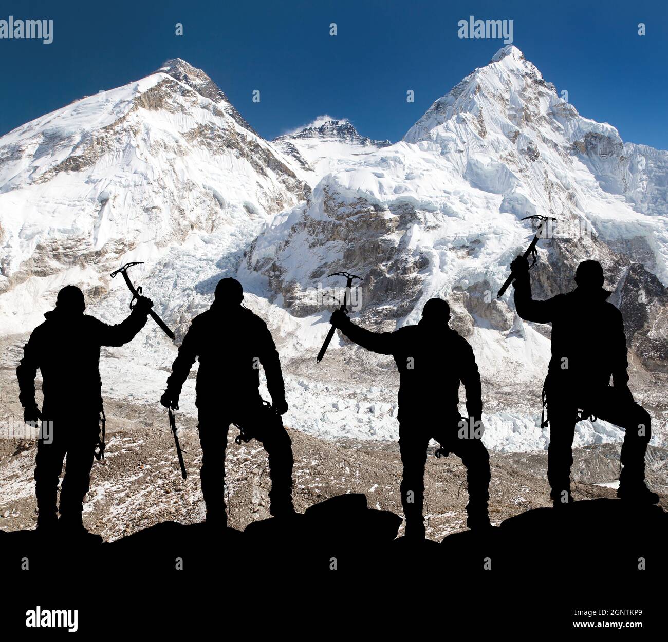 Silhouette of men with ice axe in hand, Mount Everest and Lhotse from