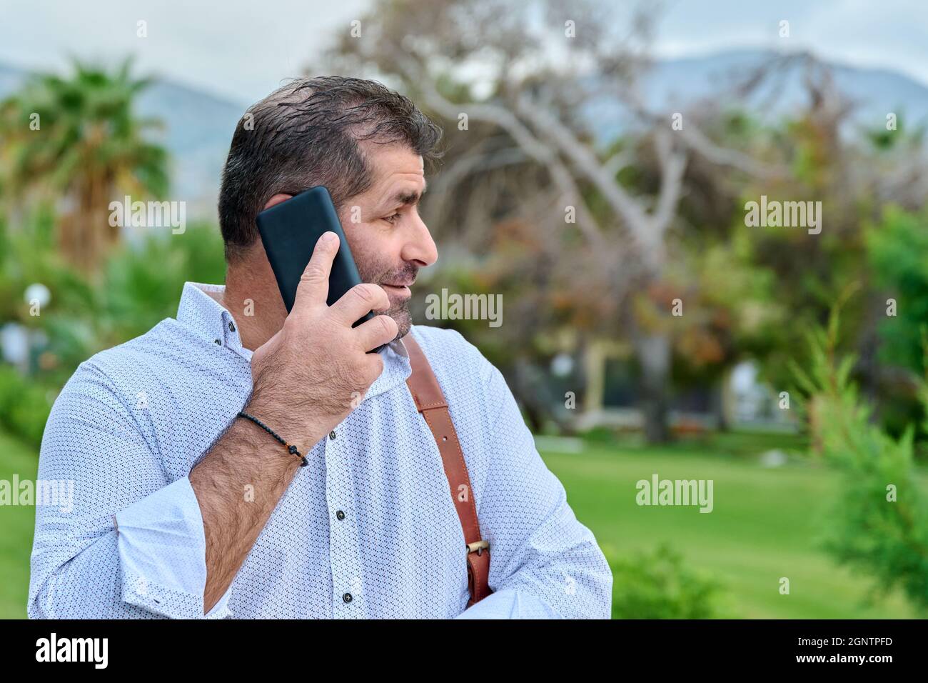 Mature business man talking on the phone outdoors Stock Photo