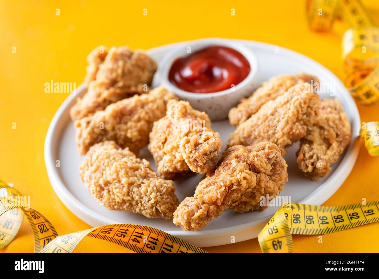 Deep fried chicken wings with tomato sauce on plate. Junk food, unhealthy eating concept Stock