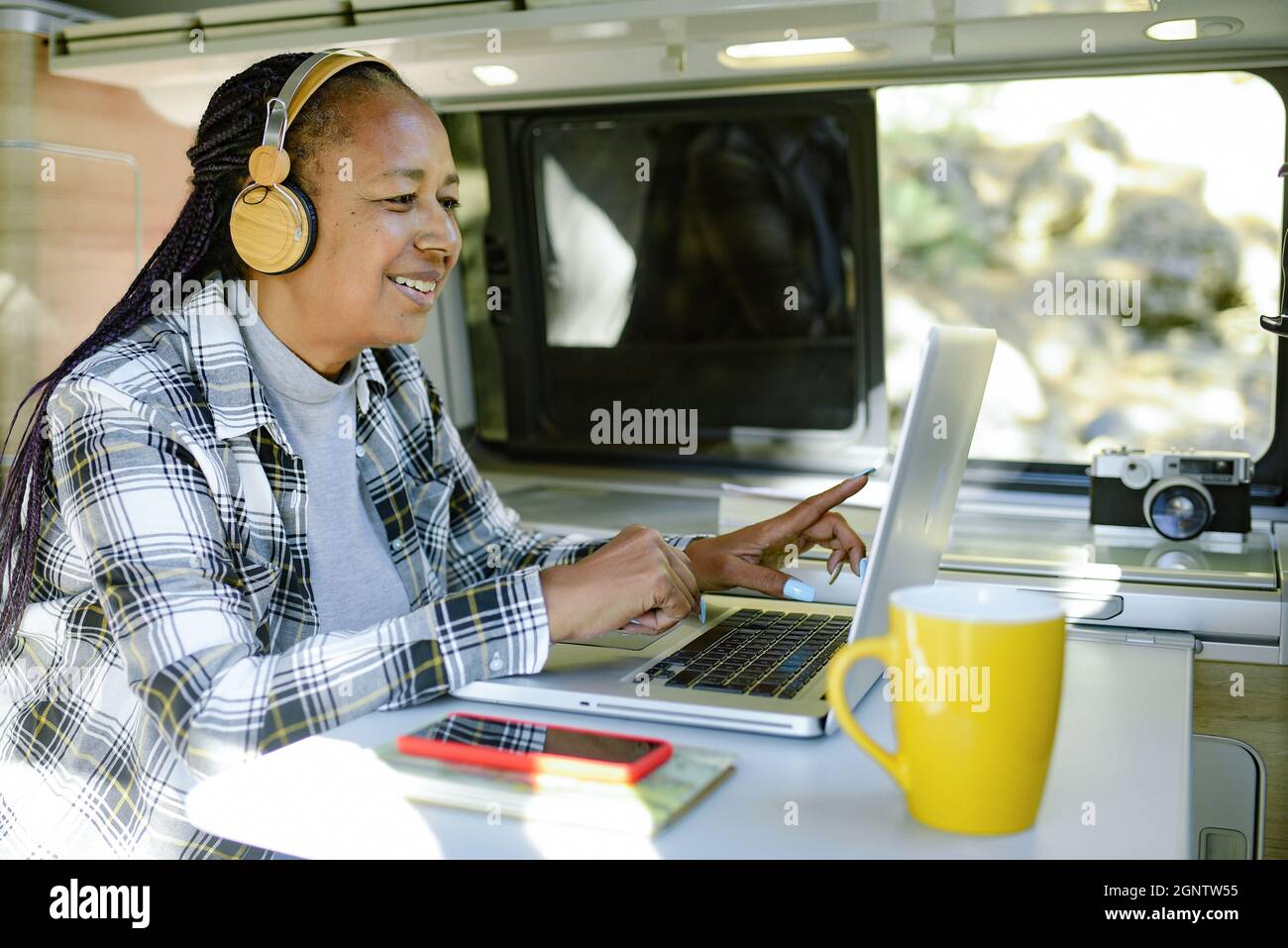 Smiling black traveler working on netbook in van Stock Photo