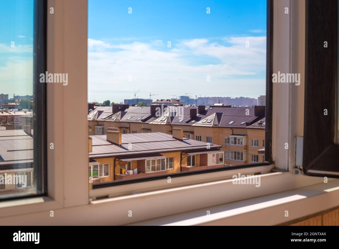 View from the window of a multi-storey building to a new village of brick houses. Construction and real estate. Stock Photo