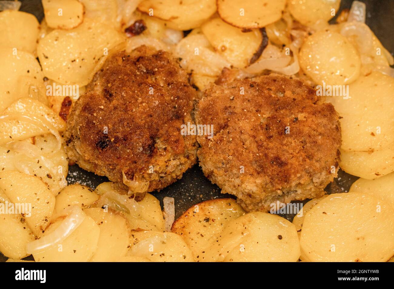 Meatballs with fried potatoes in the pan Stock Photo
