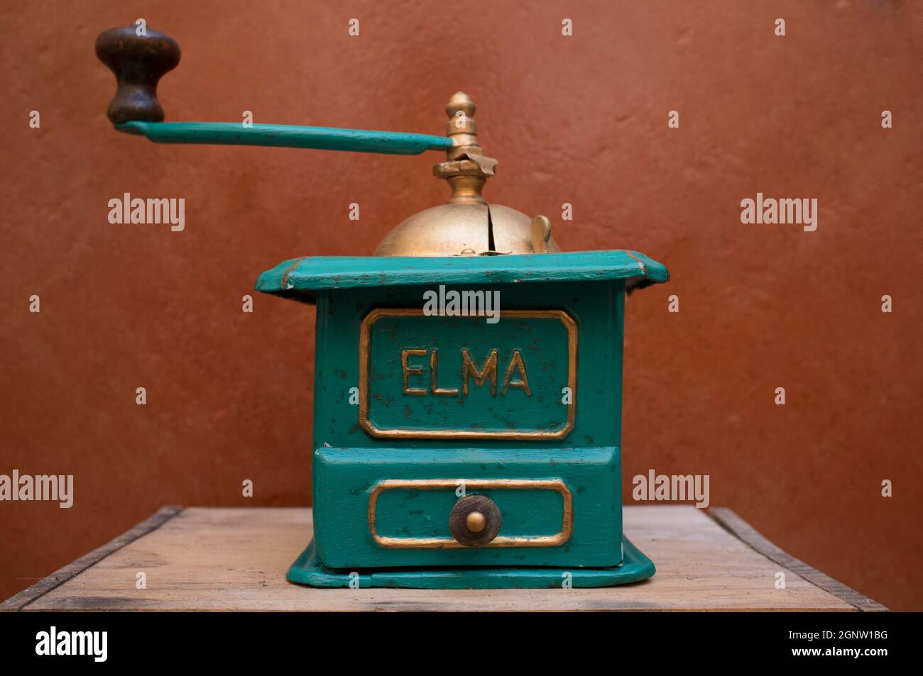 Old manual coffee grinder painted gold and green. Selective focus Stock