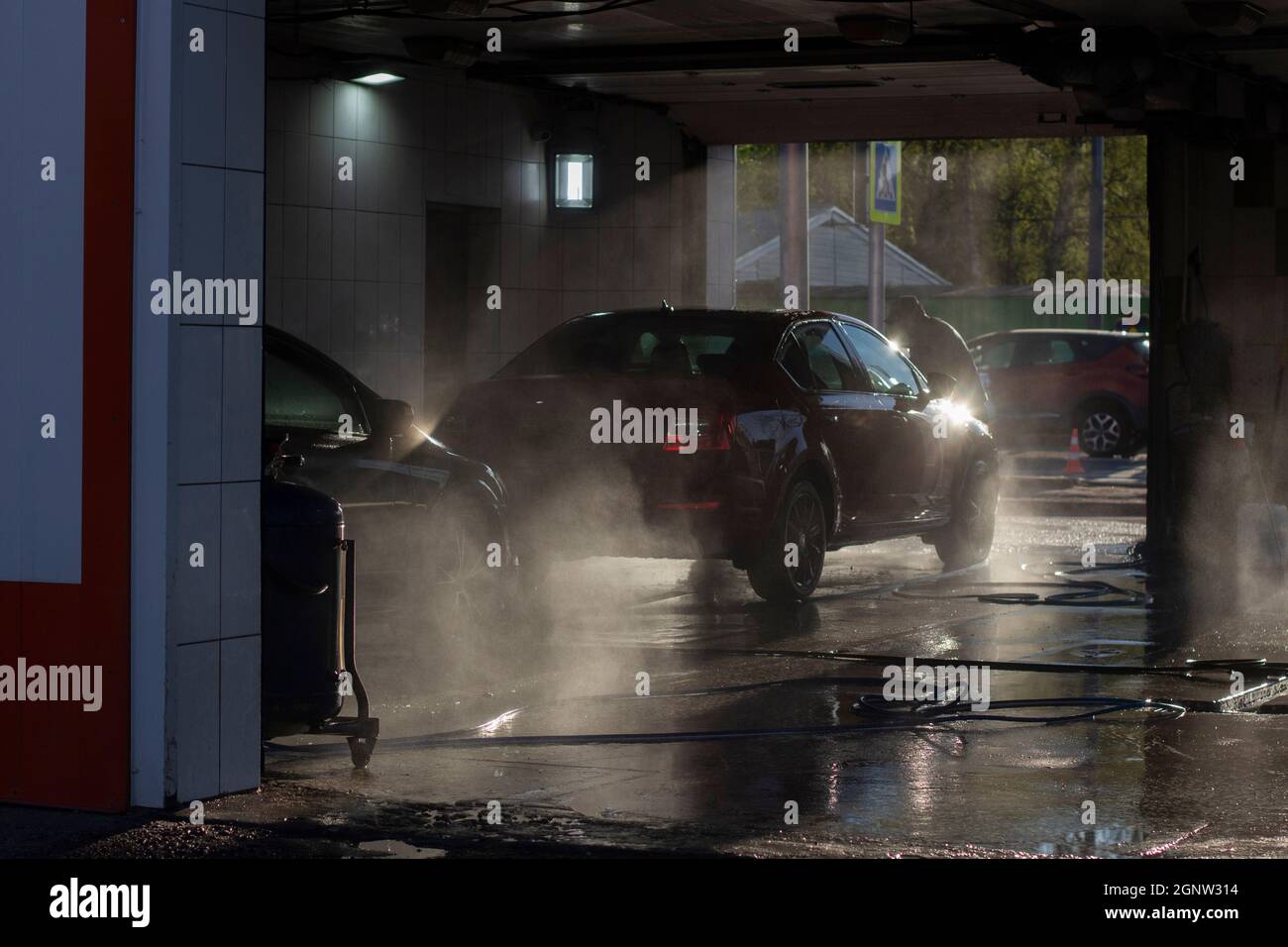 Car wash at a car wash. Workers wash their cars under the pressure of