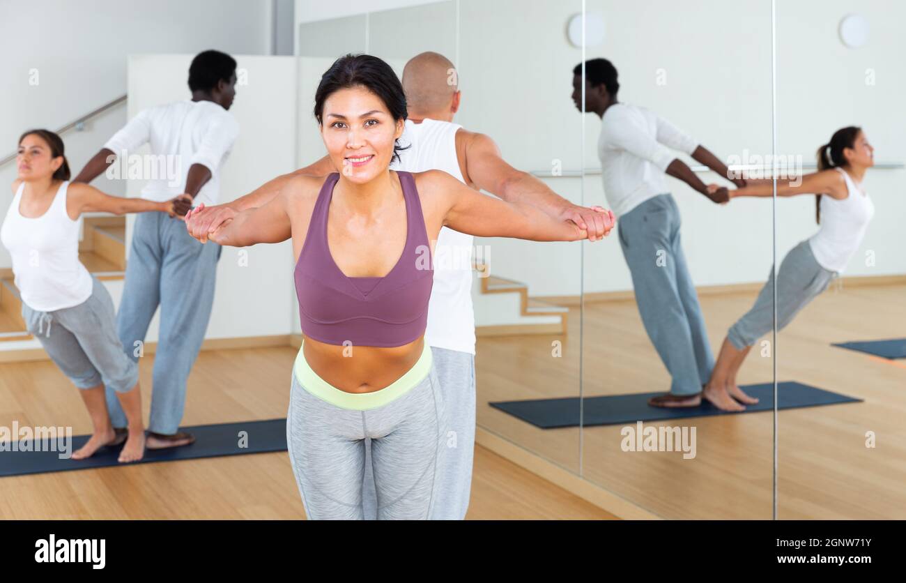 Couples practicing yoga with partner at studio Stock Photo