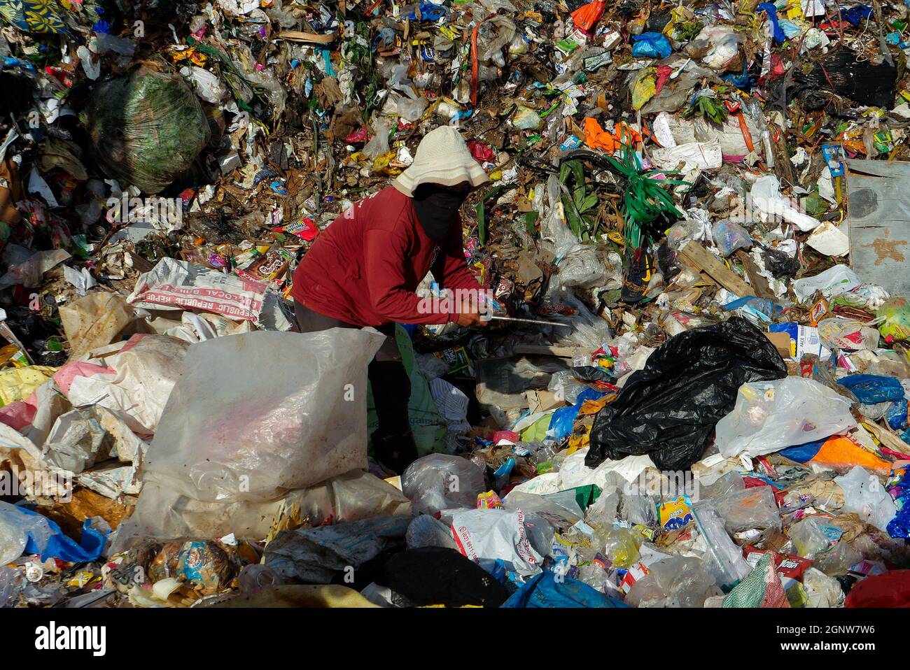 Angono, Rizal, Philippines. 24th Sep, 2021. This is Angono's dumpsite. A female scavenger digs into the pile of trash for items to be recycled or can be sold to a junk shop for a small amount of money. (Credit Image: © George Buid/ZUMA Press Wire) Stock Photo