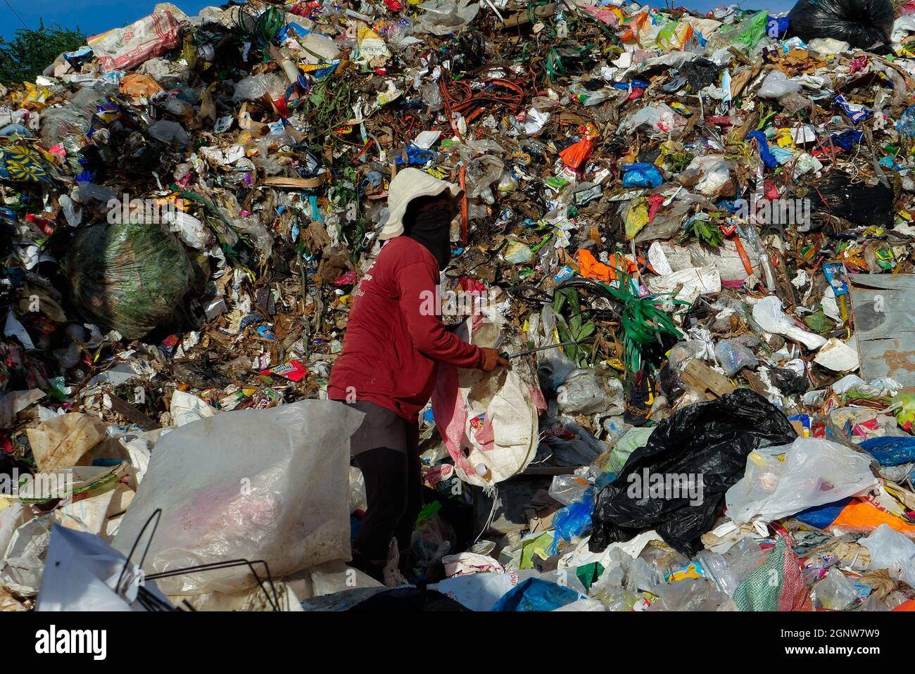 Angono, Rizal, Philippines. 24th Sep, 2021. This is Angono's dumpsite. A female scavenger digs into the pile of trash for items to be recycled or can be sold to a junk shop for a small amount of money. (Credit Image: © George Buid/ZUMA Press Wire) Stock Photo