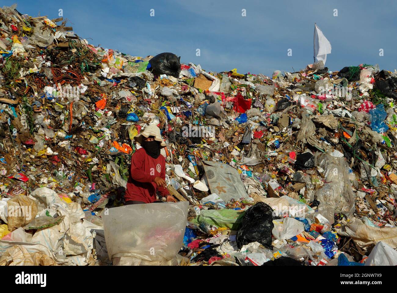 Angono, Rizal, Philippines. 24th Sep, 2021. This is Angono's dumpsite. A female scavenger digs into the pile of trash for items to be recycled or can be sold to a junk shop for a small amount of money. (Credit Image: © George Buid/ZUMA Press Wire) Stock Photo