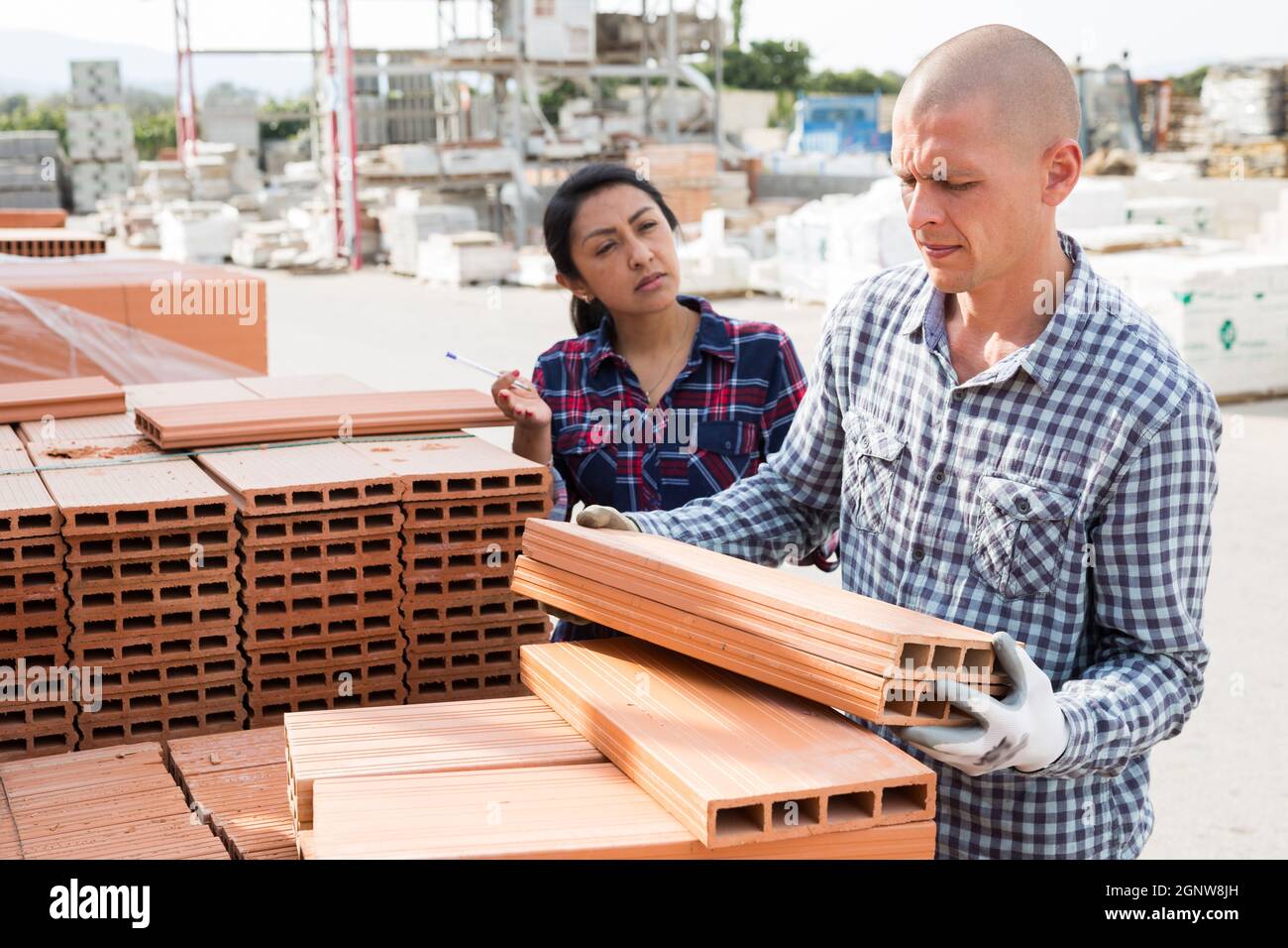 Worker stacking bricks in warehouse of materials Stock Photo Alamy