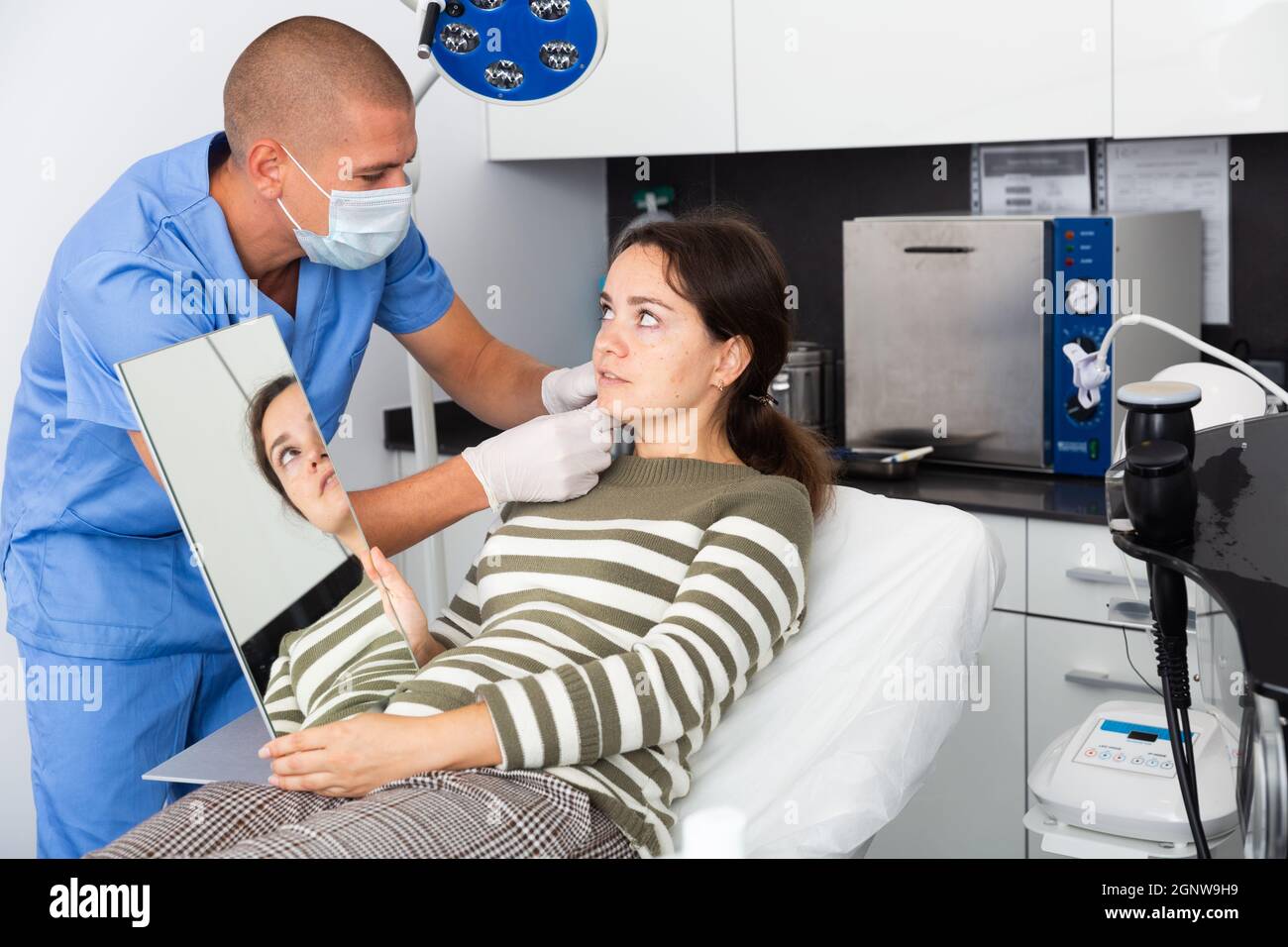 Cosmetician explaining hardware facial procedure to female client Stock ...