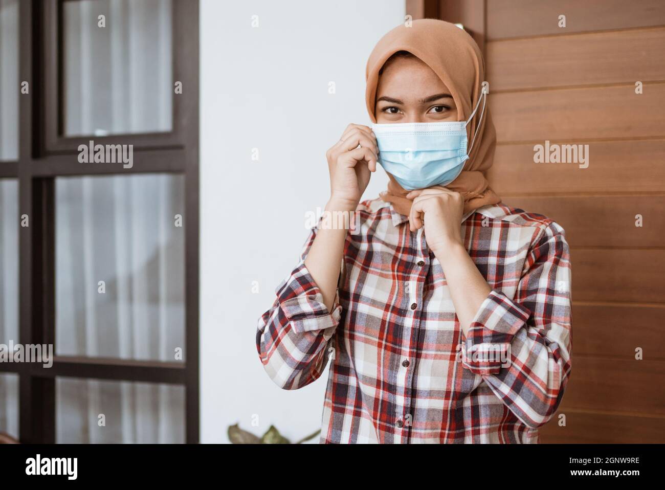 Coronavirus. Asian woman putting on a medical disposable mask to avoid ...