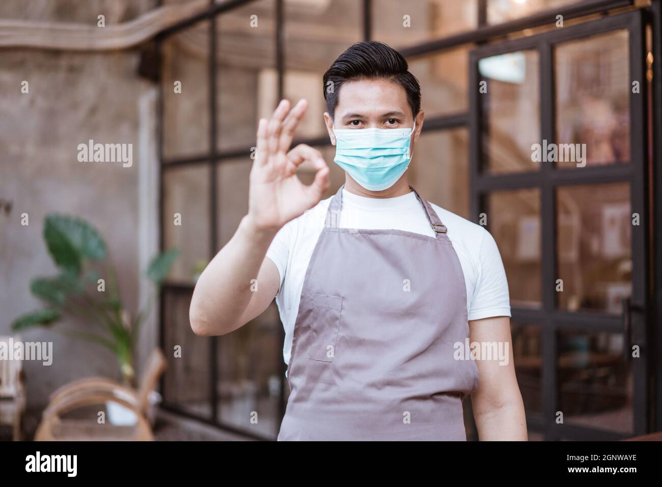 Waitress wearing a face mask at the coffee shop Stock Photo - Alamy