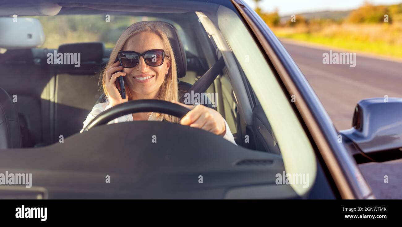 Woman talking on mobile and driving Stock Photo