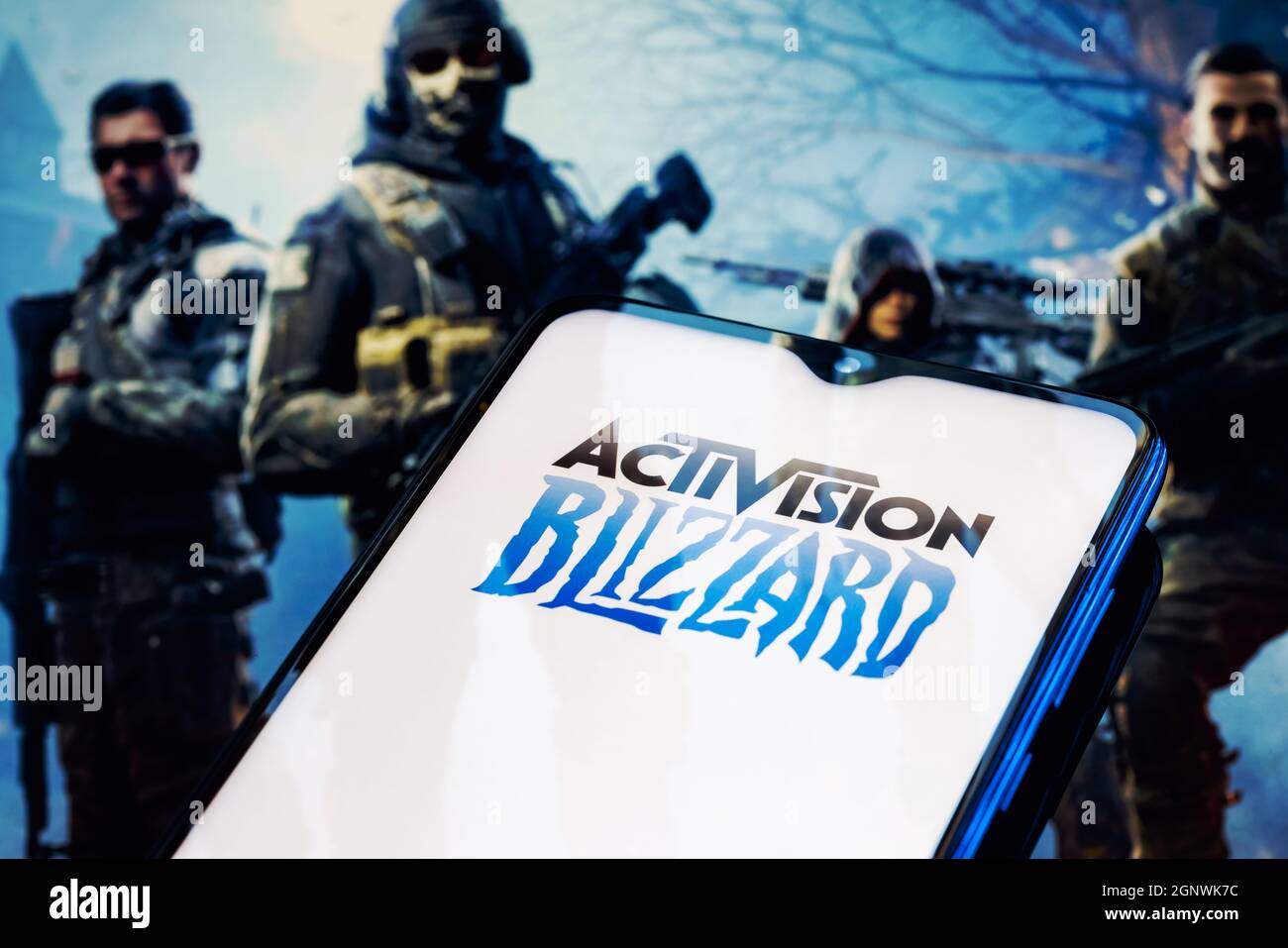 Activision Blizzard logo on smartphone screen. A frame from the Call of Duty on the background. Stock Photo