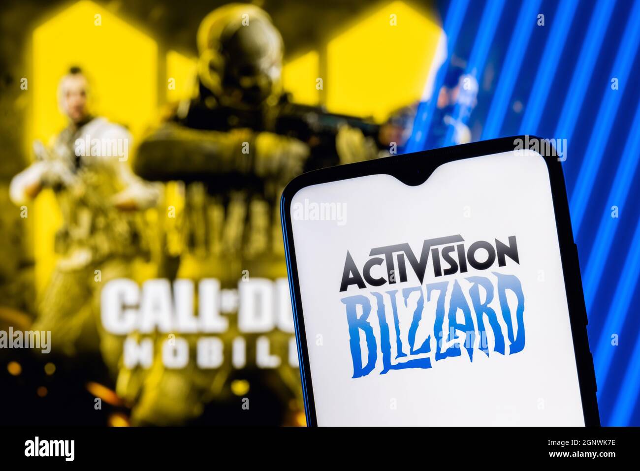 Activision Blizzard logo on smartphone screen. A frame from the Call of Duty on the background. Stock Photo
