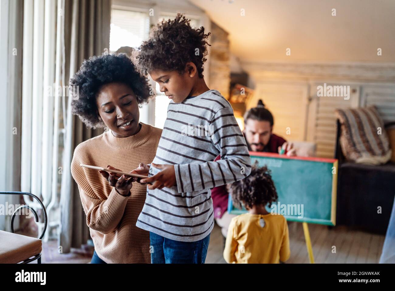 Happy family using tablet for playing game watching movies, relaxing at