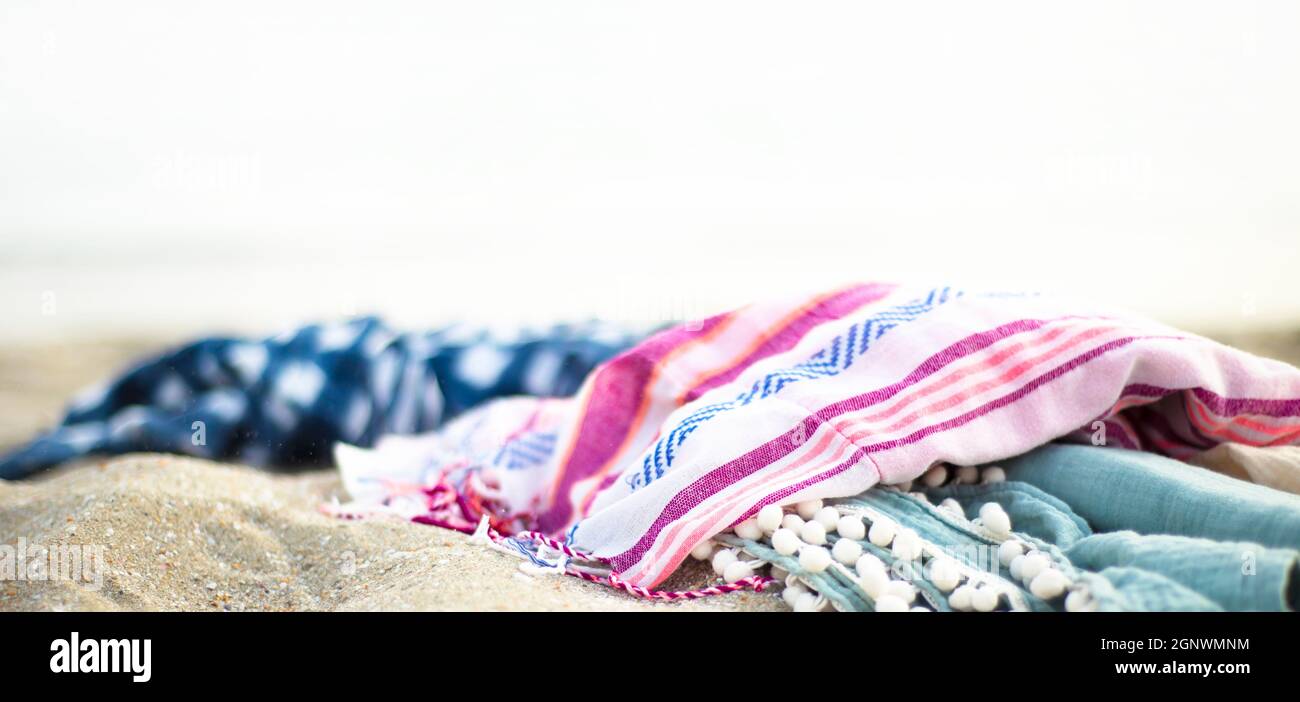Bright colored towels on the beach in boho style. Beach textiles Stock ...