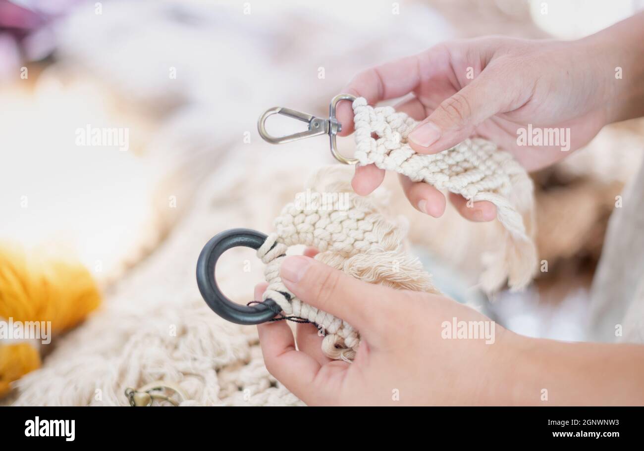 Female hands choosing the hand-made Macrame beige thread Hanger with ...
