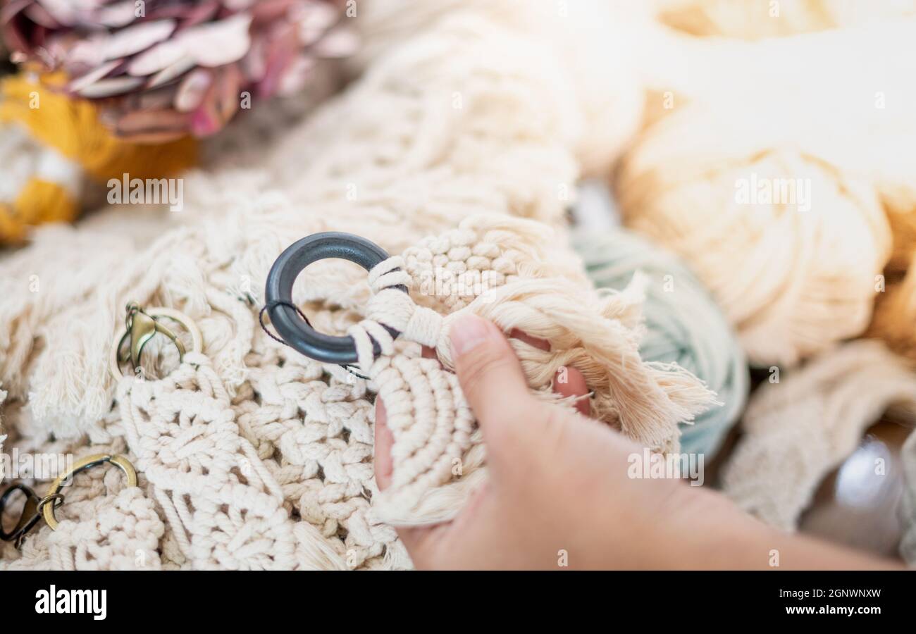 Female hands holding hand-made of Macrame beige thread Hanger with wood ...