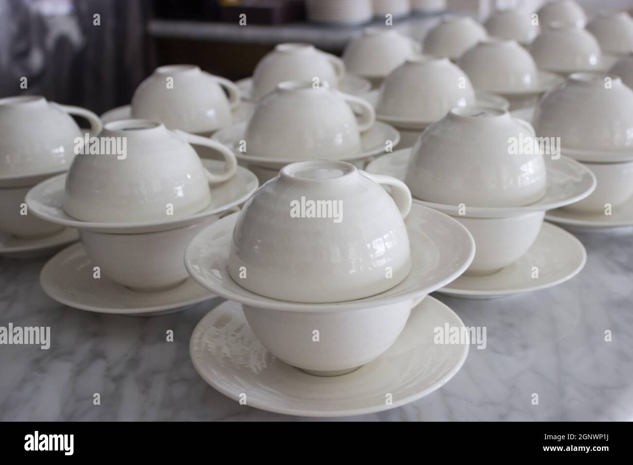 set of white ceramic cup and saucers display in restaurant Stock Photo