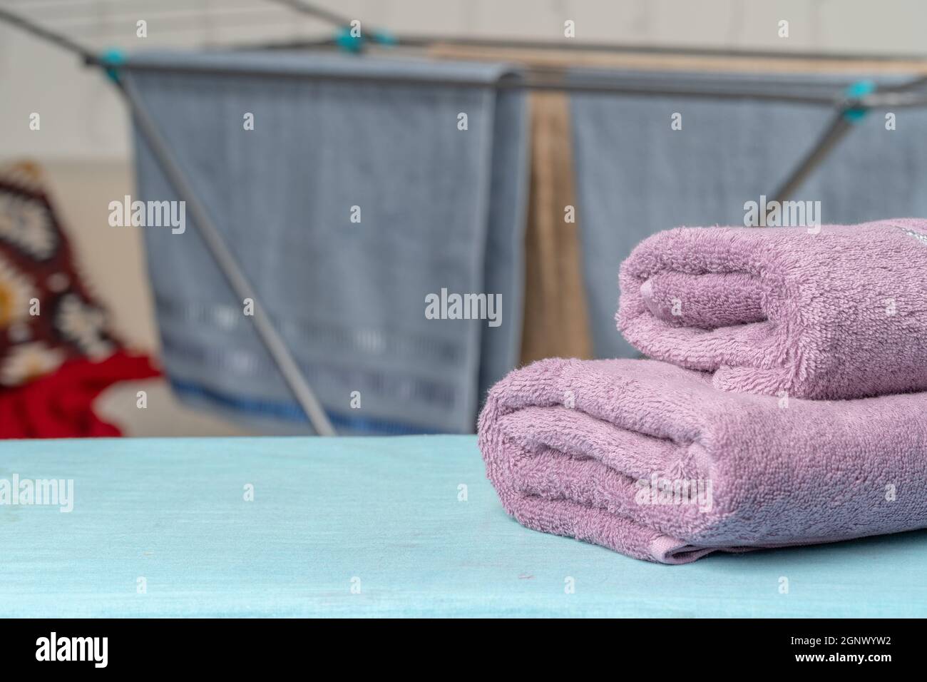 Housework concept. Ironing towels on ironing board Stock Photo