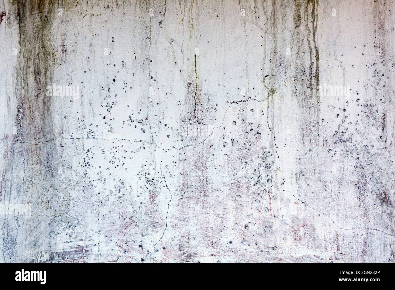 Old whitewashed weathered distressed cracked cement stone wall texture background Stock Photo