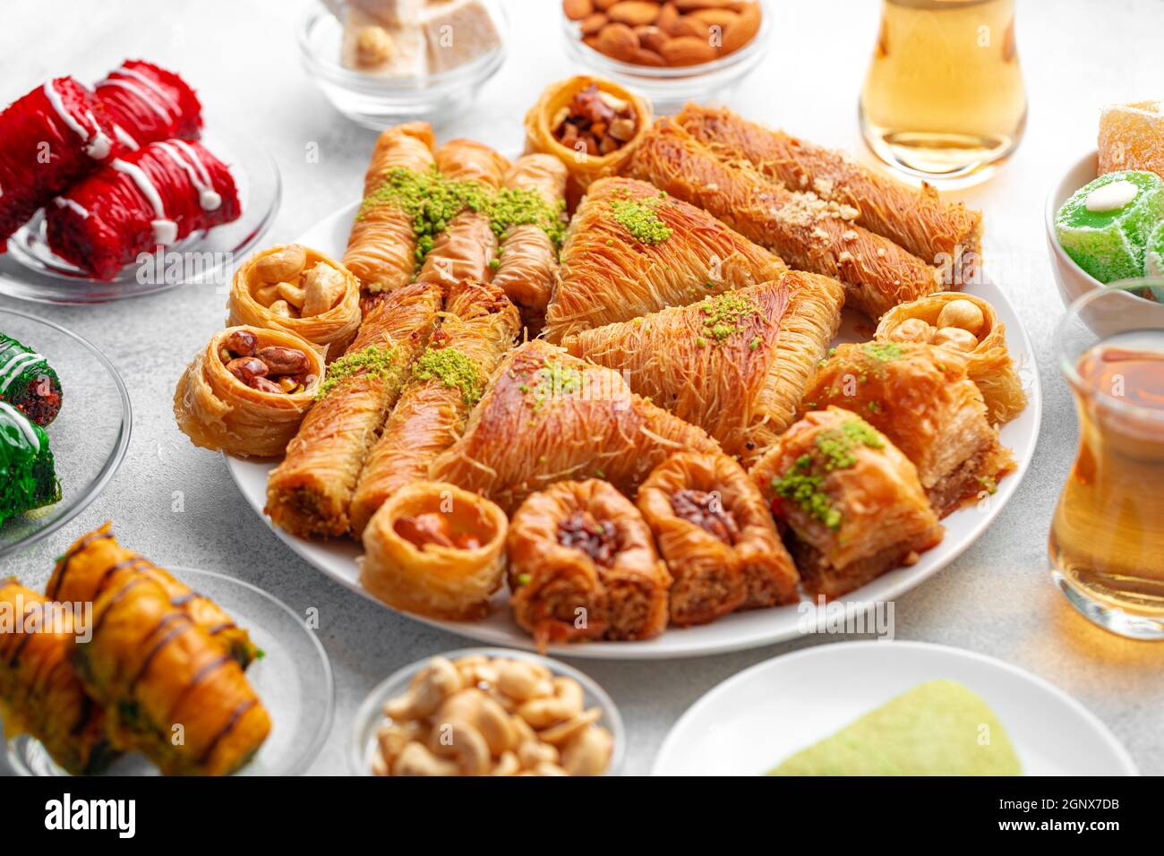 Various Turkish sweets and cup of tea on white textured background ...