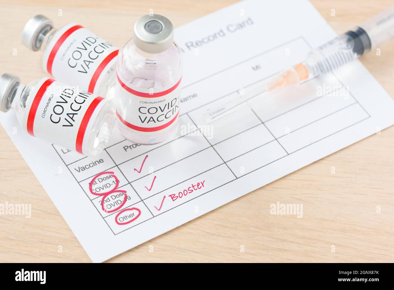 Vaccination record card showing booster dose of covid-19 vaccine. The thrid vaccination for immunity against delta variant. Stock Photo
