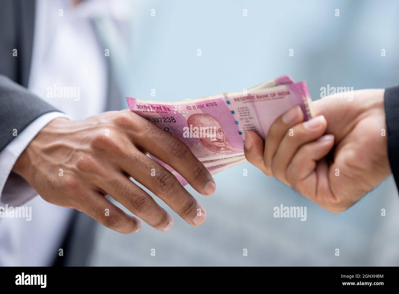 Businessman hand giving money Indian rupee currency to partner, loan and bribery concepts Stock Photo