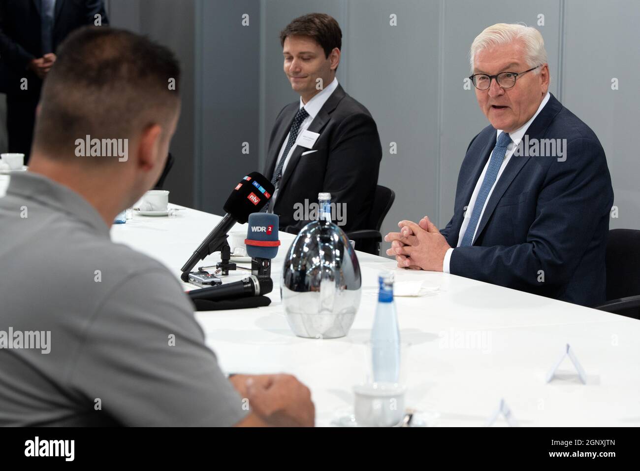 28 September 2021, North Rhine-Westphalia, Mülheim an der Ruhr: Federal President Frank-Walter Steinmeier (r) sits at the table with employees of FWH Stahlguss GmBH. Steinmeier visits the Ruhr region and commemorates 60 years of the German-Turkish recruitment agreement. Photo: Federico Gambarini/dpa Stock Photo