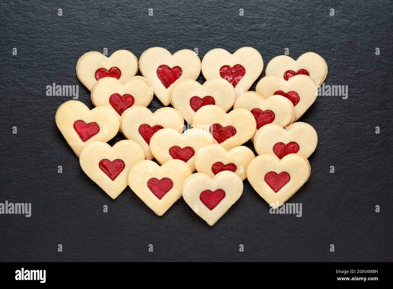 Homemade christmas cookies hearts with strawberry jam on slate table Stock Photo
