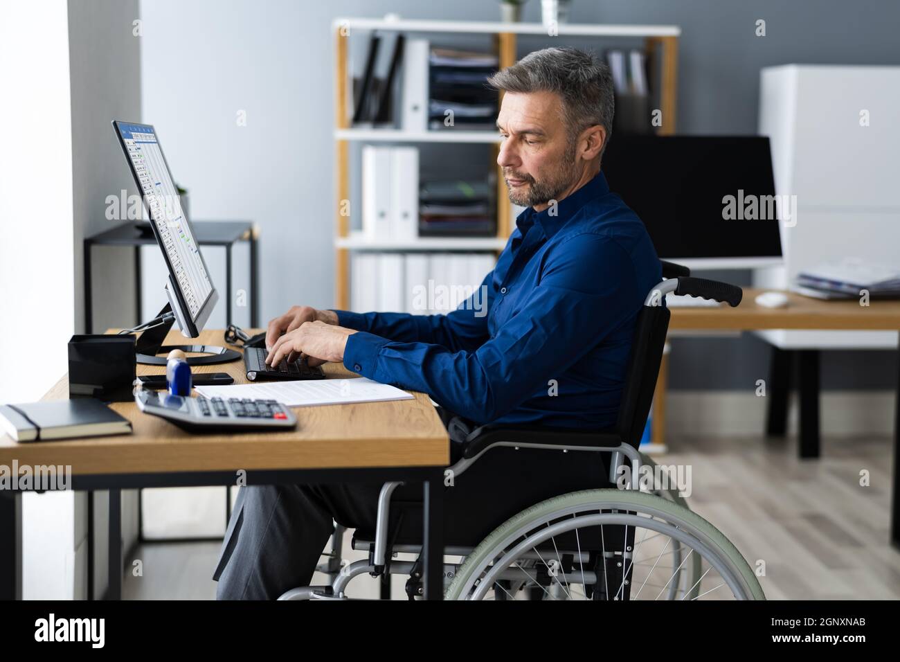 Disabled Handicapped Man In Wheelchair Working Using Computer