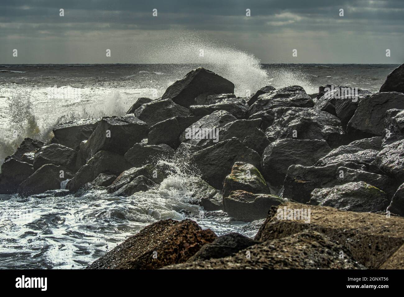 The north sea crashes against the rocks with high waves and foam spray. North Sea, Denmark, Europe Stock Photo
