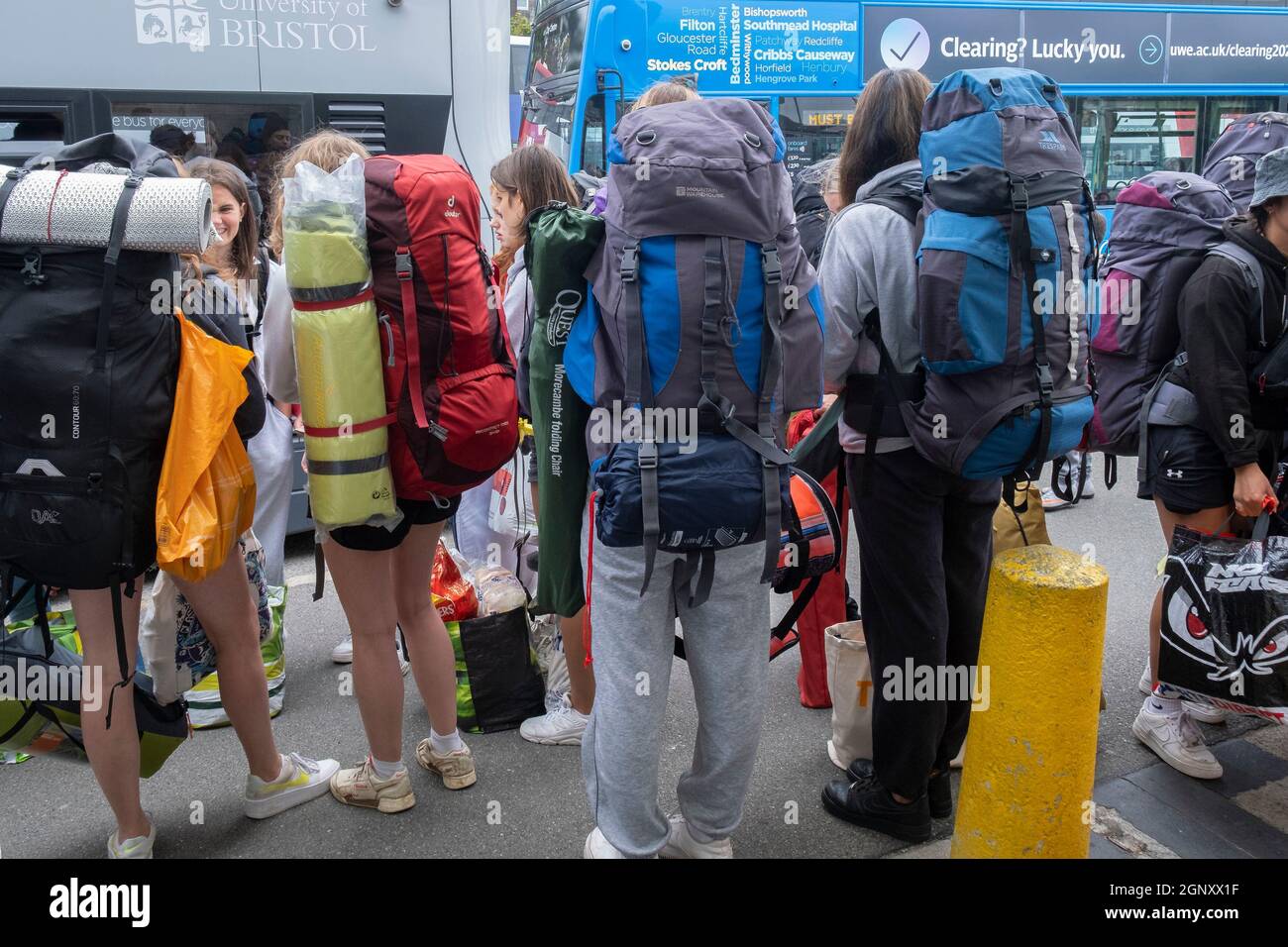 Young people carrying heavy rucksacks and queueing for buses to take them to the opening day of The Boardmasters Festival in Cornwall. Stock Photo