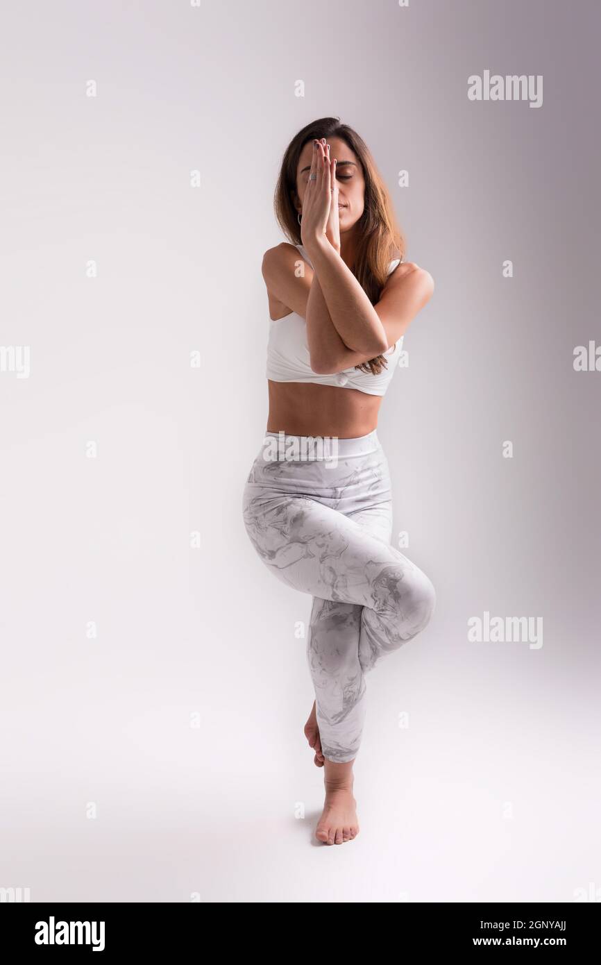 Sporty young woman doing yoga practice isolated on white background ...