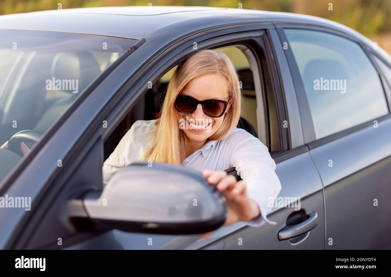 Female driver adjust side mirror Stock Photo Alamy