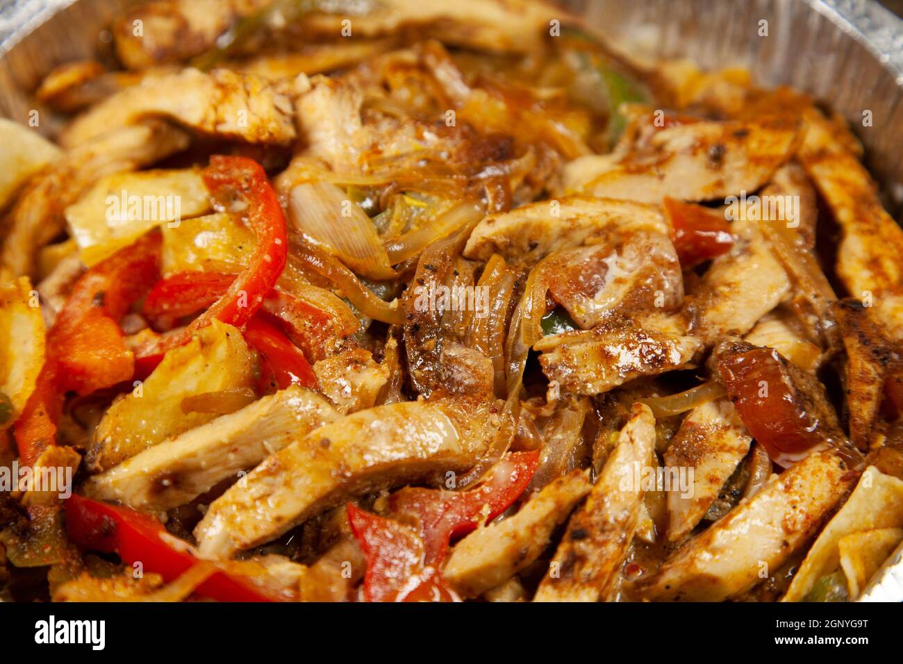 Shredded chicken, red and green bell peppers, and roasted onions in an