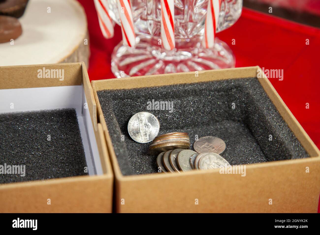 Pennies, nickels, dimes, quarters, and dollar coins in a gift box next