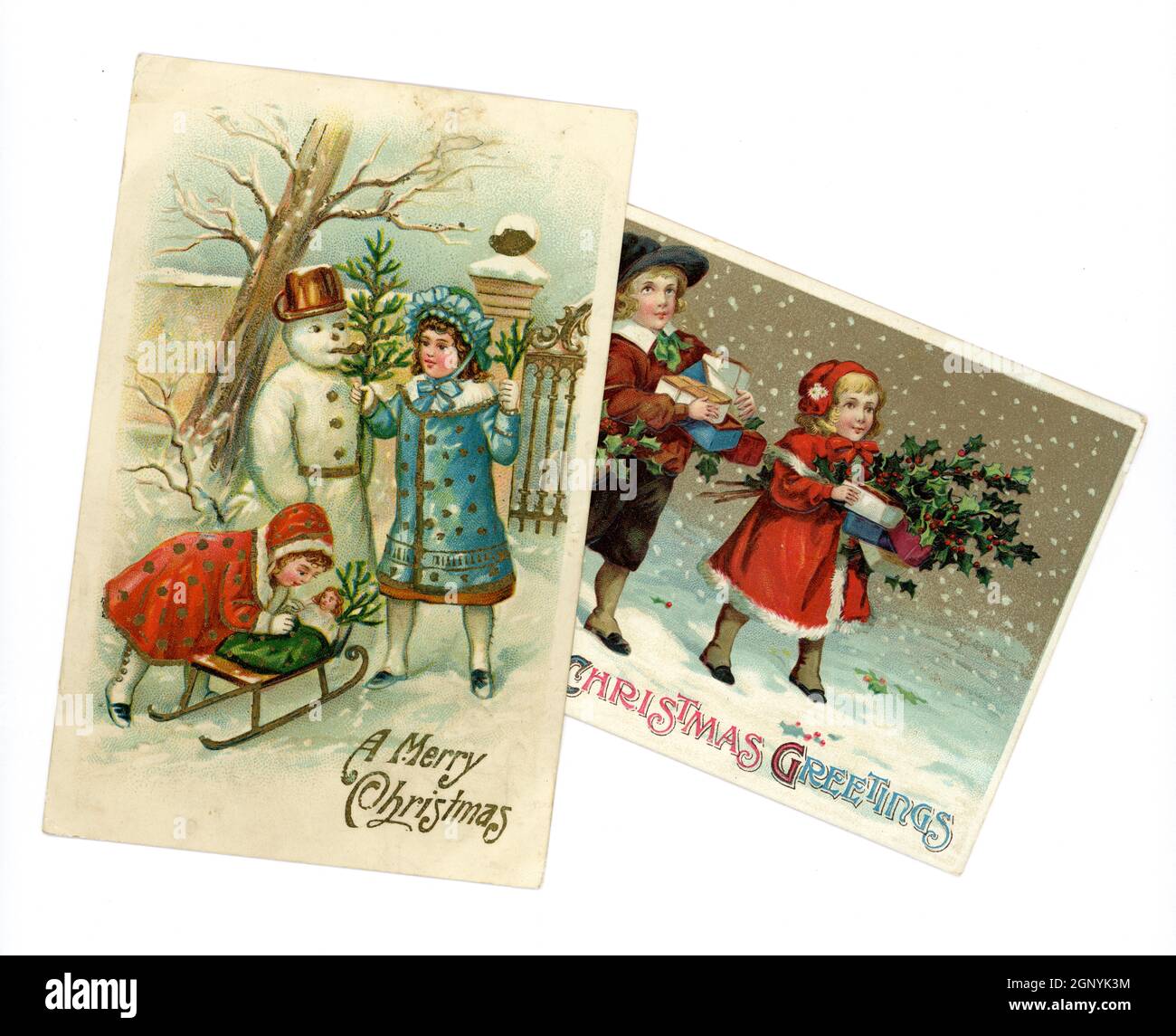 Original embossed Edwardian era Christmas greetings postcards printed in Germany, of cute young children wearing winter clothes fashionable at this time, building a snowman and bearing gifts, circa 1910, U.K. Stock Photo