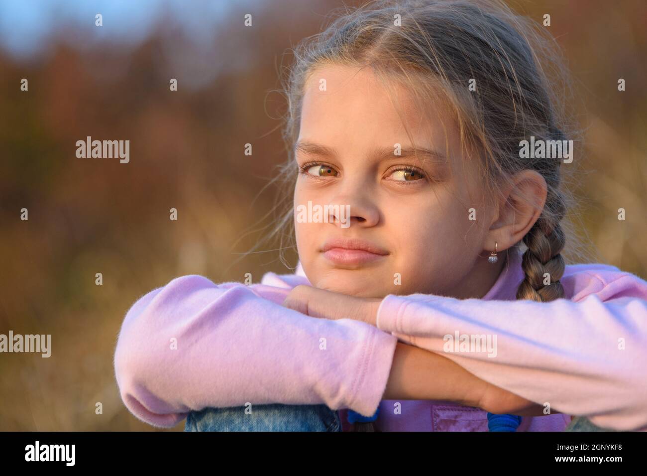 Portrait of a thoughtful beautiful ten-year-old girl at sunset Stock Photo
