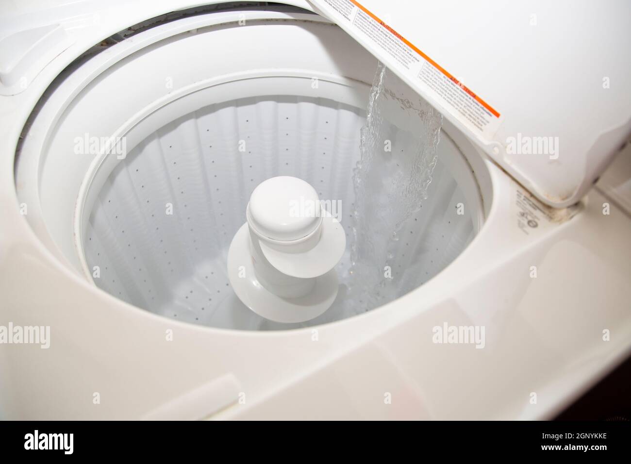 Close up of water flooding into an empty washing machine Stock Photo