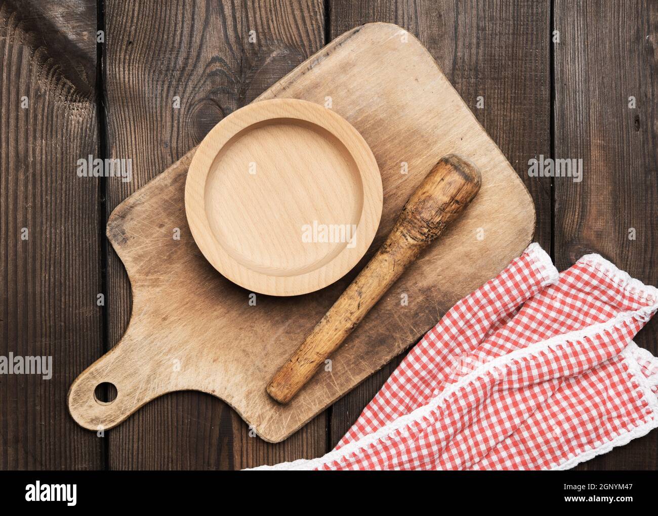 empty plate and old brown rectangular wooden kitchen cutting board on the table, top view Stock Photo
