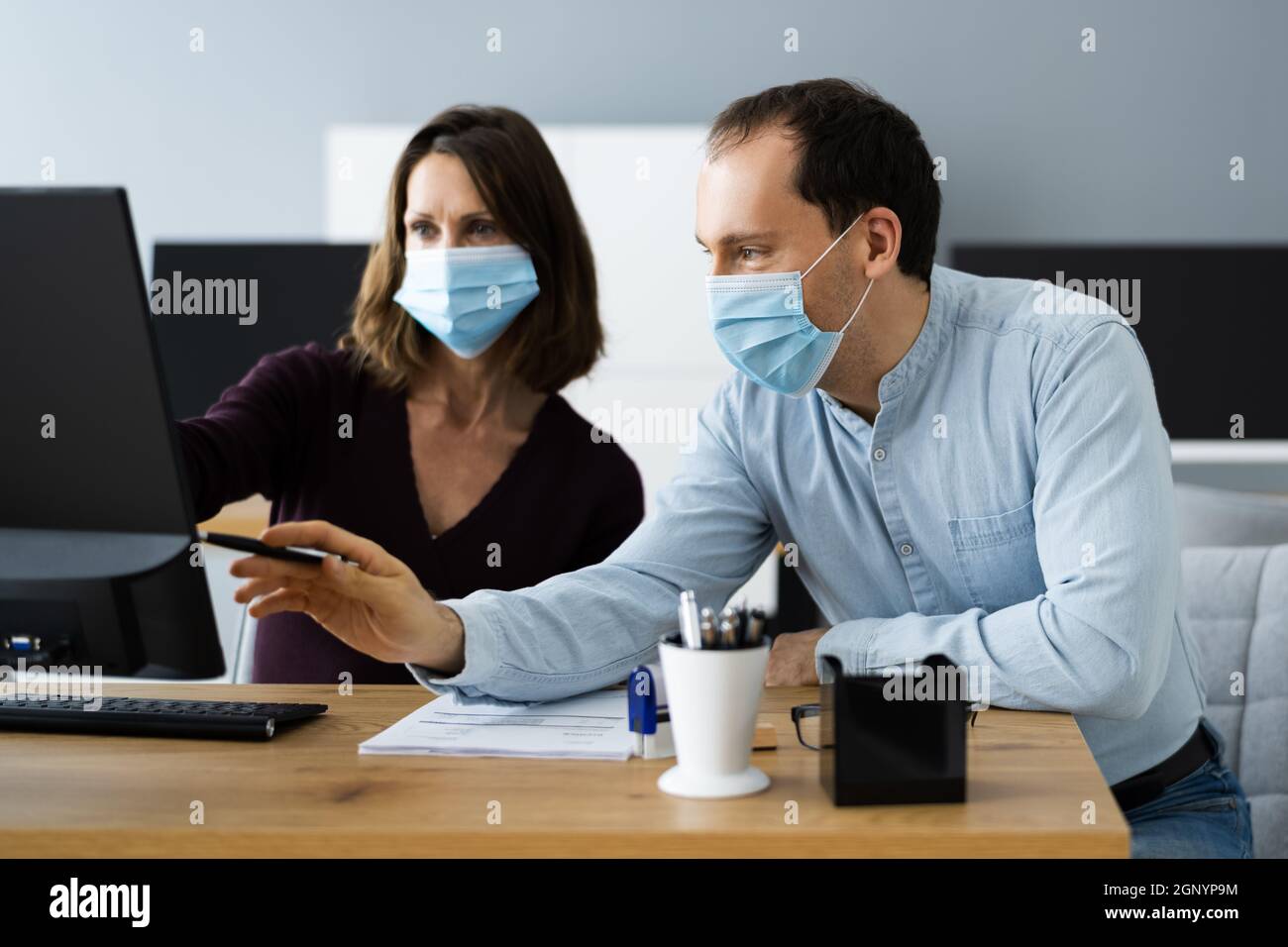 Manager Training Business People At Computer In Face Mask Stock Photo