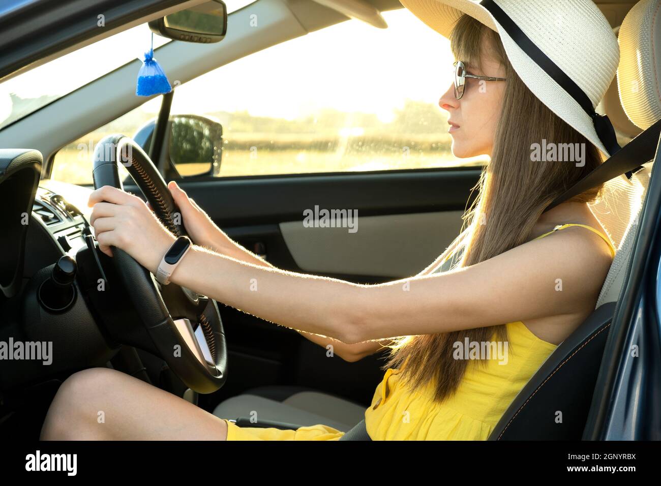 Young woman driver in summer yellow dress and straw hat driving a car Stock Photo Alamy