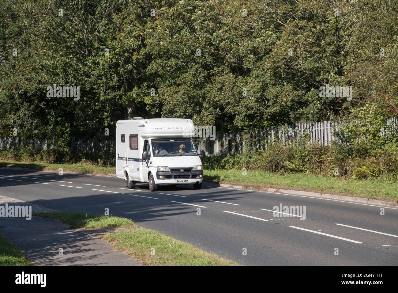 Autotrail motorhome travelling uphill on country road in Cornwall. For UK motorhomes, campervans, staycations in UK, alternative holidays. Copy space. Stock Photo